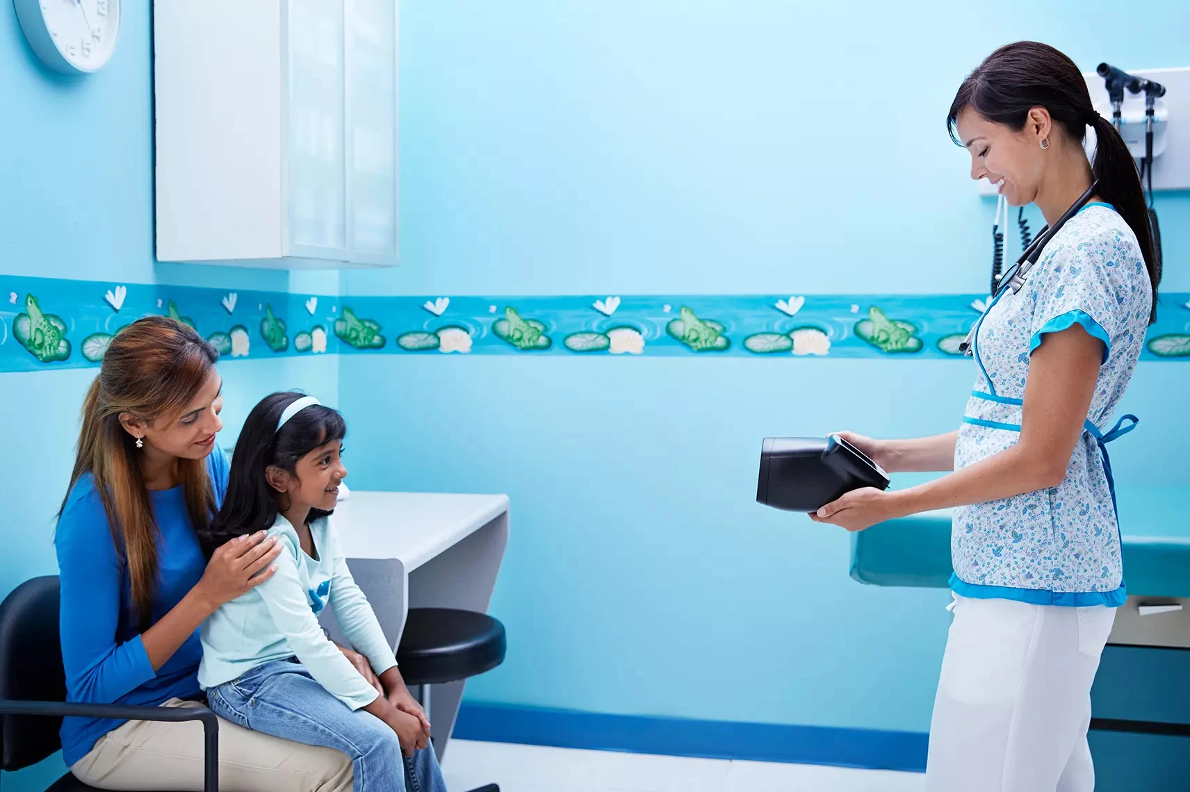 Physician screening child and parent in office with Spot Vision Screener